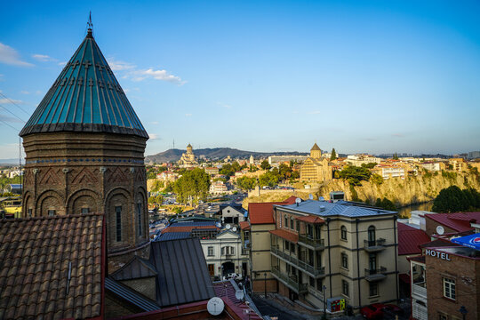 Historic Tbilisi cityscape view with Sioni Cathedral Bell Tower, Metekhi Church, and Holy Trinity Cathedral, Georgia.