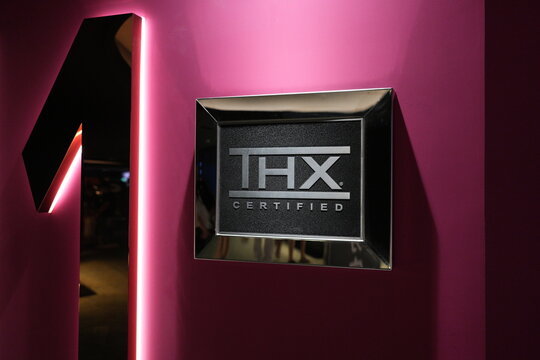 A THX certified sign next to a neon number one at a cinema entrance.