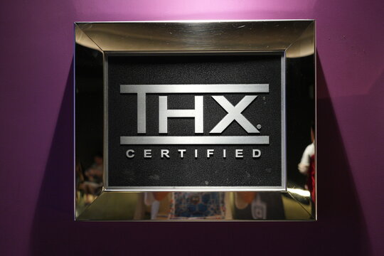 A front view of a THX certified sign on a purple wall.