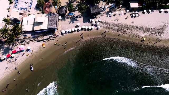 Top Down Drone View of Beachfront Resort and Ocean Bay in Ecuador, Umbrellas, Palm Trees, Sandy Shore and Tropical Coastal Travel Scene