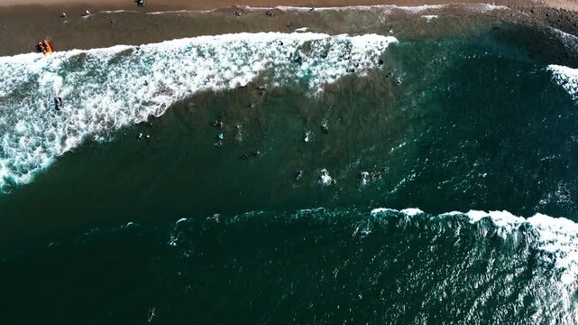 Aerial View of Surfers in Breaking Waves on Ecuador Beach, Dark Pacific Water, White Surf, Sandy Shore and Coastal Recreation Background