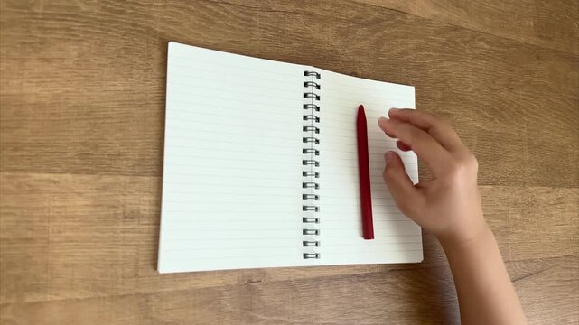 Child Holds a Red Pen Ready to Write Then Lays It Down on a Lined Notebook, 4K