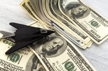 Fototapeta premium military miniature toy airplane on dollars background