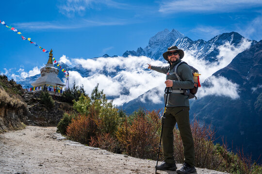 Hombre senderista se&ntilde;alando una estupa budista, en su camino al Everest Base Camp, en Nepal	