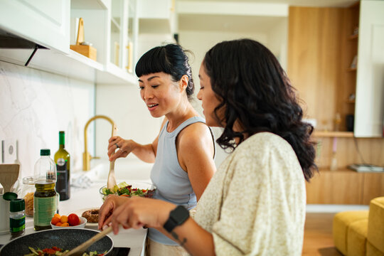Two women cooking together in modern home kitchen