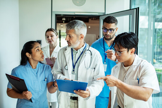 Doctors and nurses discussing patient case in hospital corridor