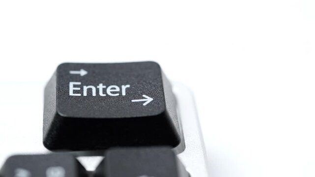 Close-up of a black Enter key on a computer keyboard against a white background
