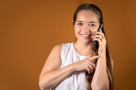 Mujer sonriente y exitosa usando su tel&eacute;fono en una llamada. Concepto de comunicaciones y atenci&oacute;n