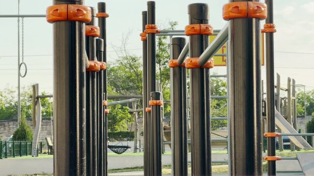 Sturdy workout bars stand empty on a sunny playground. This quiet fitness area feels peaceful yet highly motivating for an active day. The bright scene inspires energetic joy.