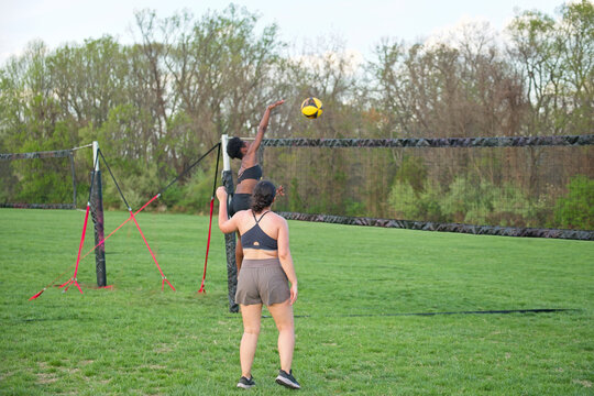 Female volleyball player hitting the ball during a doubles grass match