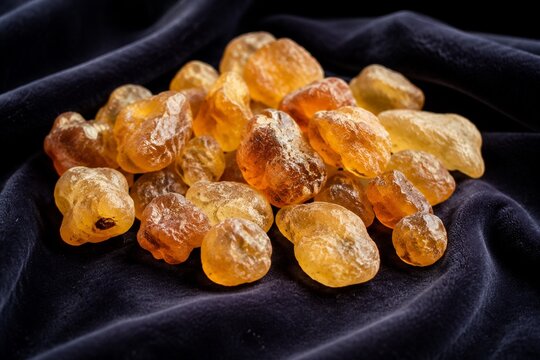 Translucent amber frankincense resin pieces on dark velvet cloth.