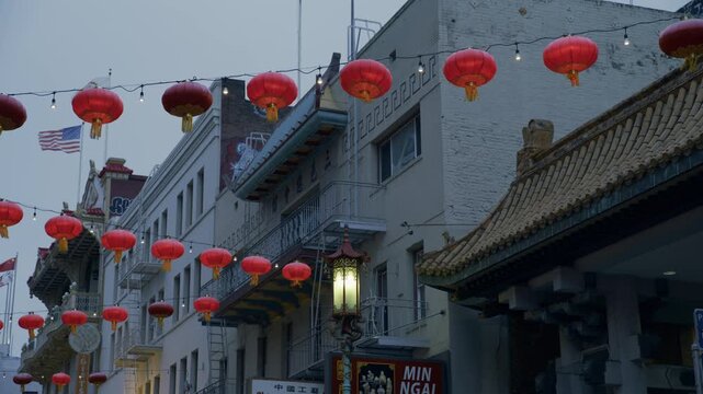 Red Lanterns Strung Above Chinatown Street Buildings In San Francisco At Dusk With Overcast Sky
