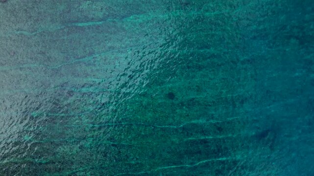 Overhead perspective ocean waves breaking over shallow coral reef. Great aerial view drone