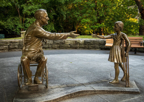 New York, NY - US - Jul 1, 2026 The FDR Hope Memorial on Roosevelt Island features bronze statues of Franklin D. Roosevelt in a wheelchair and a young girl on crutches, symbolizing hope and resilience