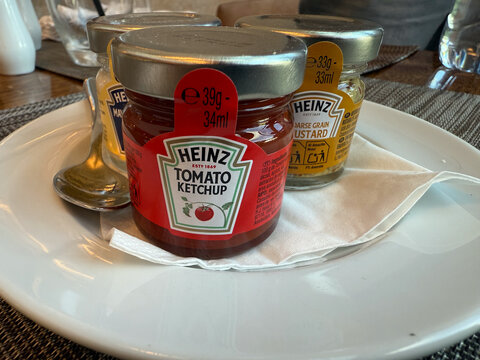 ALBUFEIRA, PORTUGAL - OCTOBER 27, 2025: heinz tomato ketchup displayed on a white plate, top-down view.
