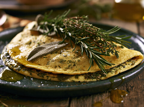 Herb Crepe with Rosemary, Sage and Olive Oil on Dark Ceramic Plate, Rustic Italian Food