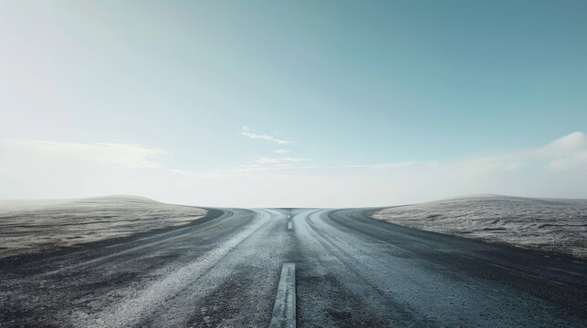 A lonely asphalt road splits into two paths in a vast, desolate landscape under a clear sky