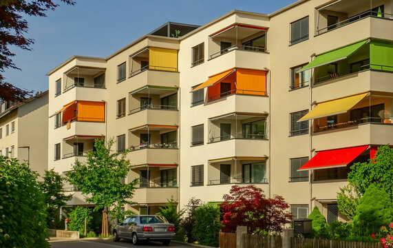 Modern apartment building facade with colorful awnings on balconies, concept of contemporary residential architecture and urban living