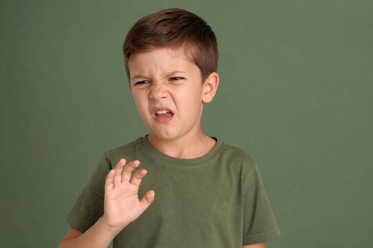 Visceral aversion of a little boy expressing disgust toward an unseen presence