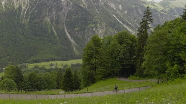 Cyclist on a drop bars road bike enjoying an epic ride and scenic cycling route on a winding paved mountain road through beautiful alpine valleys of Oberstdorf in Bavarian Alps destination