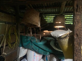 A cluttered warehouse interior with stacked sacks and bags under dim lighting. © kawankerja