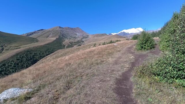 POV 4k video hiking on a mountain trail toward Gergeti glacier in Kazbegi Georgia.