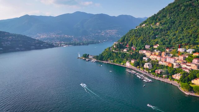 Stunning aerial shot of Lake Como, Italy, in summer with emerald hills, waterfront villas, and boats. Ideal for travel, luxury tourism, real estate, and destination marketing visuals