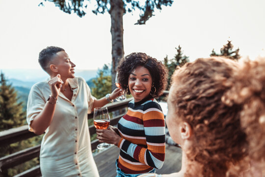 Friends enjoying wine on mountain terrace at sunset