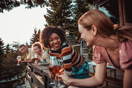 Friends toasting wine on mountain cabin deck