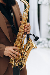 Obraz premium Musician playing golden saxophone with wireless microphone