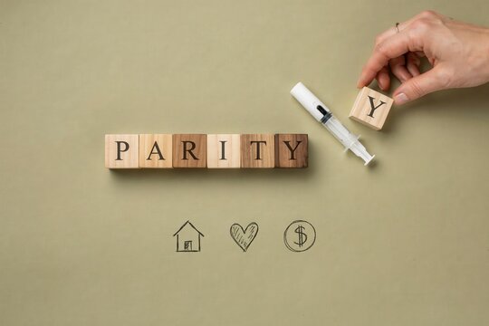 A hand holds wooden block to complete parity concept with marker on table