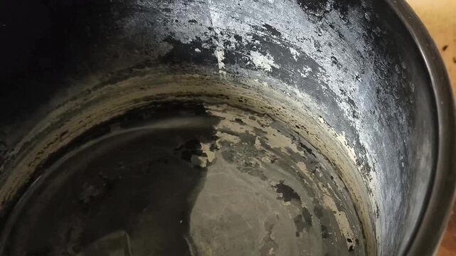 Close up of mineral scale inside saucepan caused by hard water, descaling, kitchen hygiene and home care concept.
