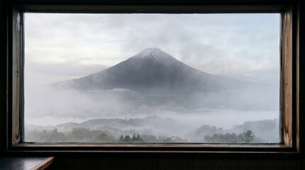 Fototapeta premium Majestic Mount Fuji shrouded in mist, framed by a rustic window.