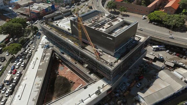 Aerial view of construction site with crane near Catavento Museum and Dom Pedro II Park in S&atilde;o Paulo, Brazil. Orbit and tilt up camera movement