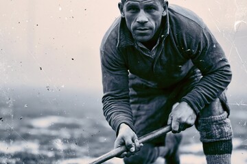 Naklejka premium Historic field hockey player gripping wooden stick on foggy grass pitch