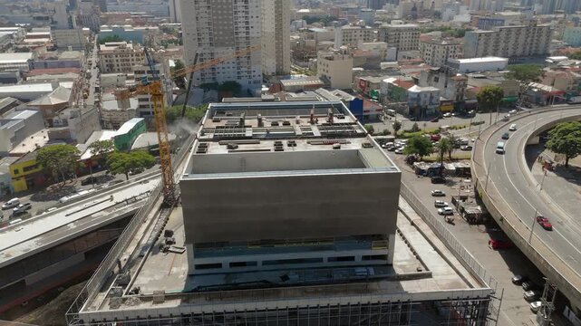 Construction of modern concrete building with tower crane in S&atilde;o Paulo, Brazil. Orbit and tilt up camera movement