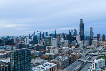 Obraz premium serene aerial drone view of chicago skyline at dusk with high-rise buildings and freeways in urban cityscape setting, modern real estate development and city planning context.