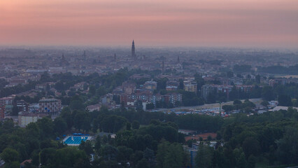 Fototapeta premium Cremona city experiencing a summer heatwave at sunrise, with Torrazzo bell tower prominent on the horizon and atmospheric haze creating a warm glow over the urban skyline