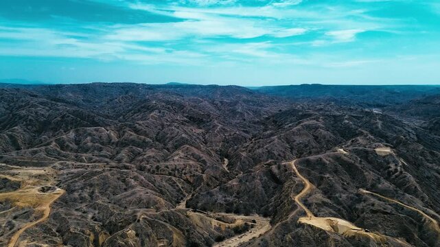Drone View of Arid Mountain Hills in Coastal Ecuador with Dirt Road, Dry Ravines, Sparse Vegetation and Rugged South American Desert Landscape