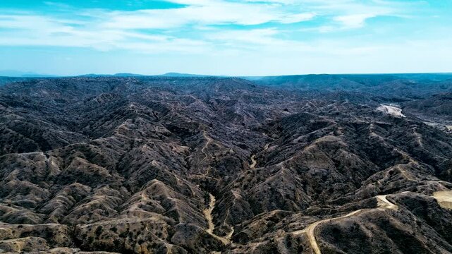 Wide Aerial View of Dry Rugged Hills in Ecuador with Dirt Tracks, Eroded Ravines, Sparse Vegetation and Remote Pacific Coast Landscape
