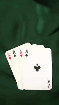 Four aces playing cards arranged on dark green elegant fabric background poker game gambling