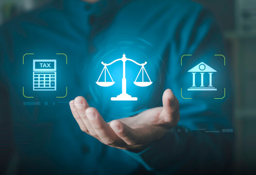 Businessman holding glowing icons of justice scales, tax law documents, banking, and financial compliance. Concept of legal advice, government regulation, and corporate law services.
