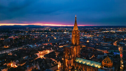 Obraz premium Strasbourg cathedral spire illuminating strasbourg city at twilight