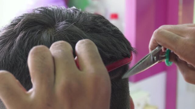 Barber giving precision haircut with scissor over comb