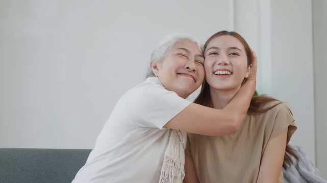 A young woman hugging her grandmother in a warm home setting, expressing love, support, family connection, senior care, and healthy aging lifestyle.