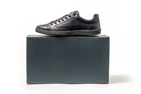 Black leather sneakers. Sport shoes with a package box isolated on white background, clipping path included