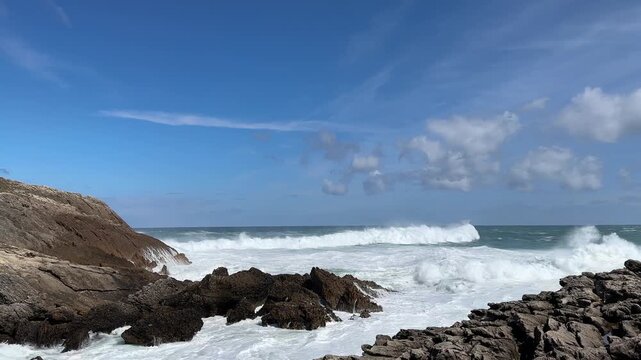 Powerful Atlantic wave swell moving along the rocky coastline as the camera slowly pans to the right.