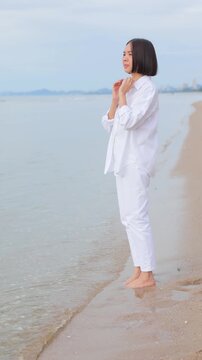 Woman walking barefoot along a peaceful beach