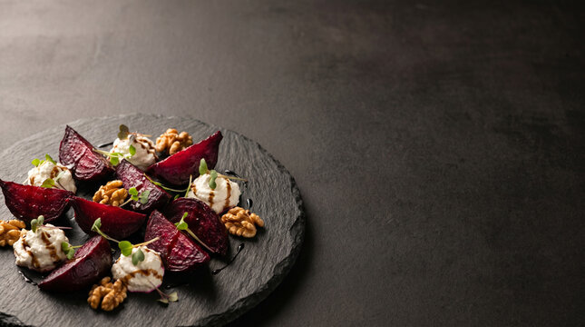 Roasted Beetroot Salad with Goat Cheese and Walnuts on a Round Slate Plate with Negative Space