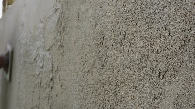 Craftsman applying wall plaster with wooden float